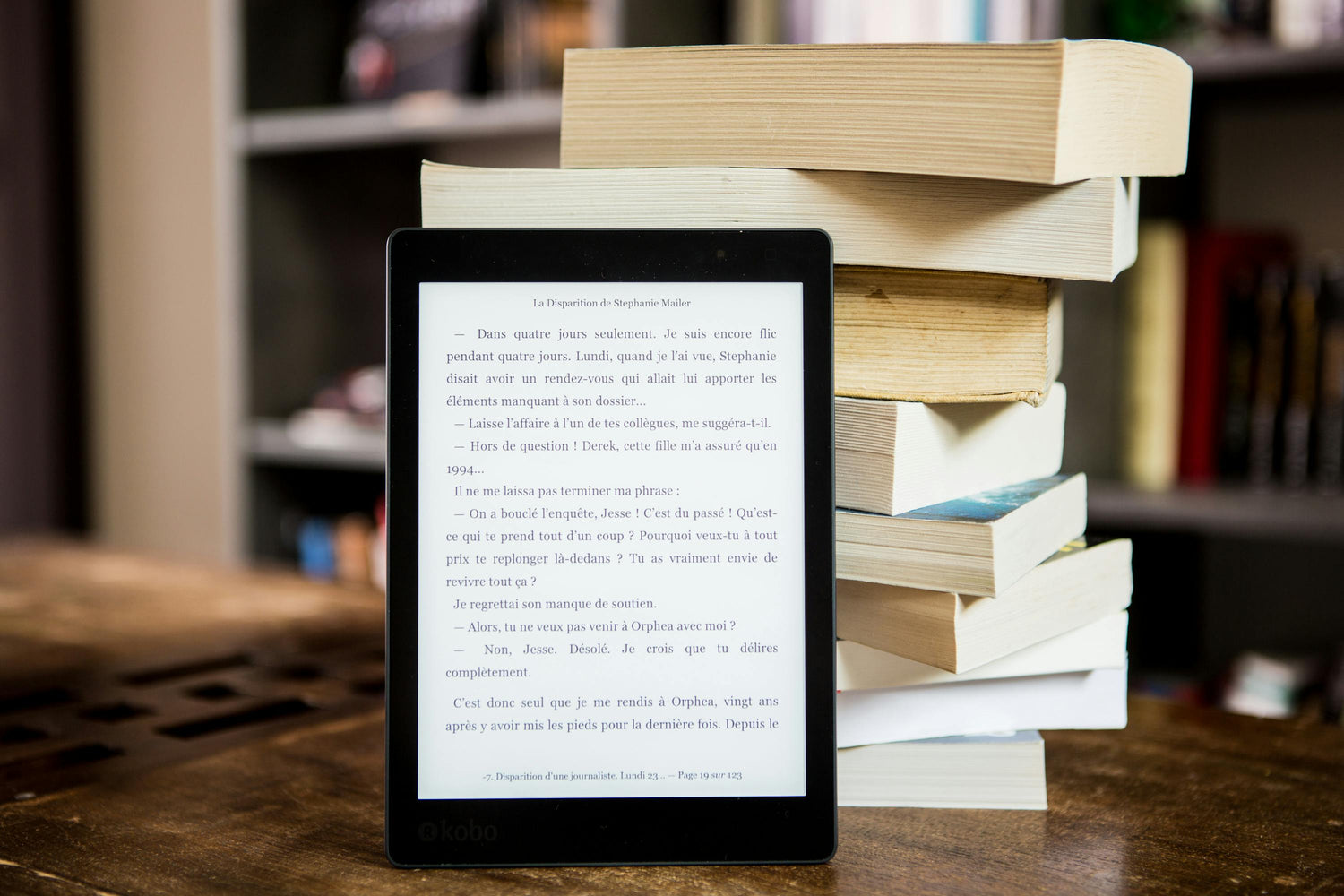 Printed books next to an e-reader showing an ebook