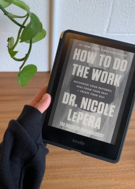 Woman reading a digital book on a Kindle in a cozy modern setting
